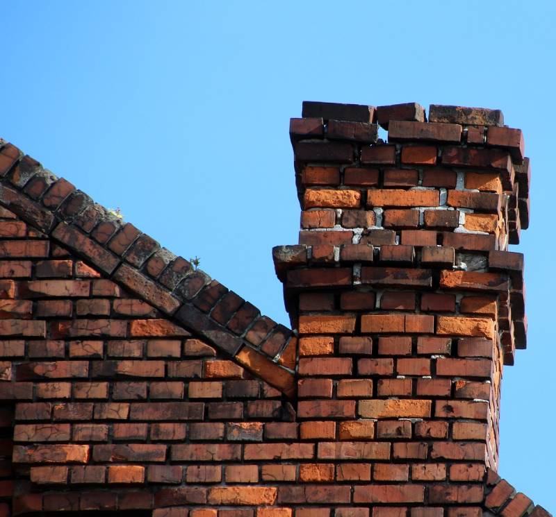 Damaged chimney on an Artesia home showing cracks and missing mortar